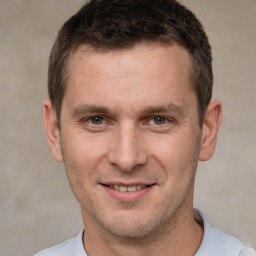 Joyful white adult male with short  brown hair and brown eyes