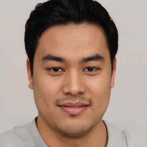 Joyful asian young-adult male with short  black hair and brown eyes