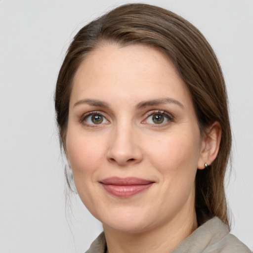 Joyful white young-adult female with medium  brown hair and grey eyes