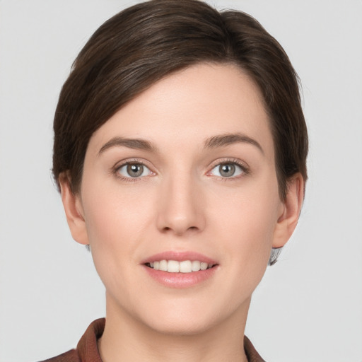 Joyful white young-adult female with short  brown hair and grey eyes