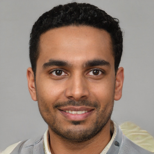 Joyful latino young-adult male with short  brown hair and brown eyes