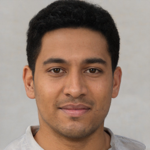 Joyful latino young-adult male with short  black hair and brown eyes
