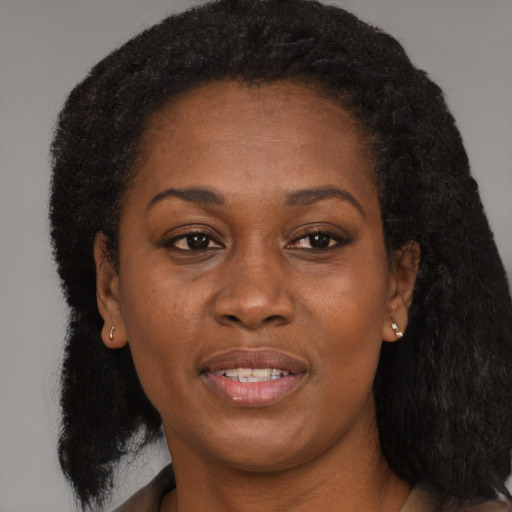 Joyful black young-adult female with long  brown hair and brown eyes