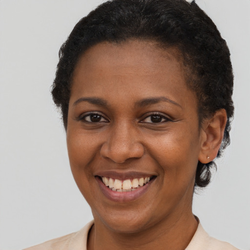 Joyful black young-adult female with short  brown hair and brown eyes