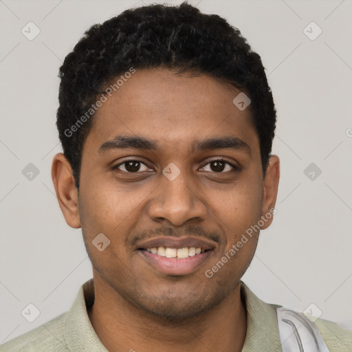 Joyful black young-adult male with short  black hair and brown eyes