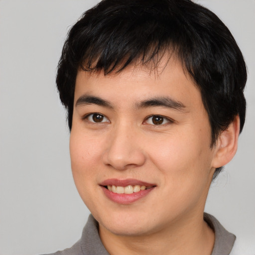 Joyful asian young-adult male with short  brown hair and brown eyes