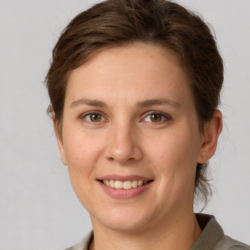 Joyful white young-adult female with short  brown hair and grey eyes