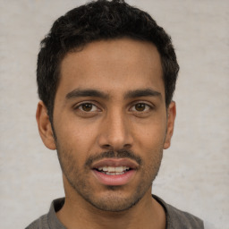 Joyful white young-adult male with short  black hair and brown eyes