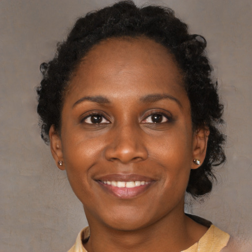 Joyful black young-adult female with medium  black hair and brown eyes