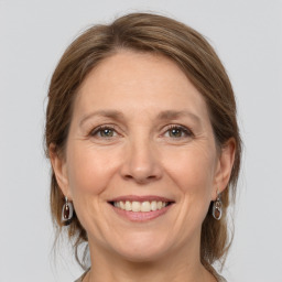 Joyful white adult female with medium  brown hair and grey eyes