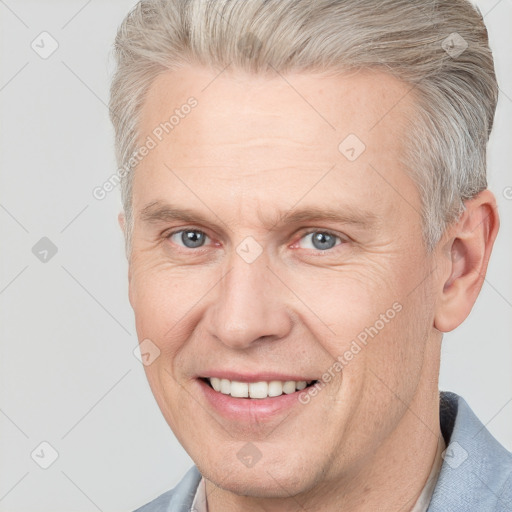 Joyful white adult male with short  brown hair and grey eyes