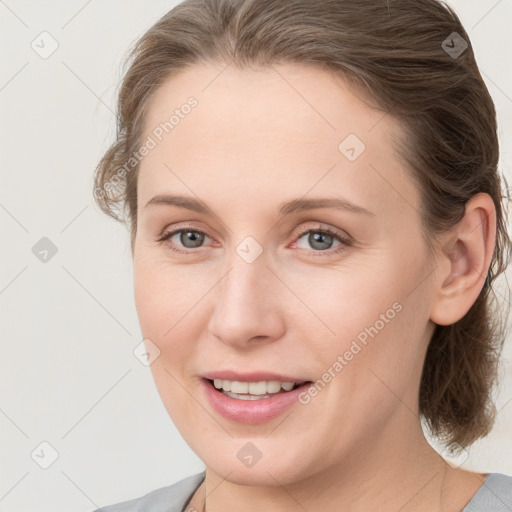 Joyful white young-adult female with medium  brown hair and blue eyes