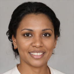 Joyful latino young-adult female with medium  brown hair and brown eyes