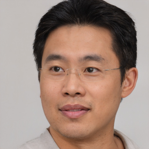 Joyful asian adult male with short  brown hair and brown eyes