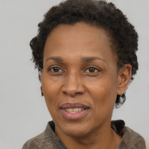 Joyful black adult female with short  brown hair and brown eyes
