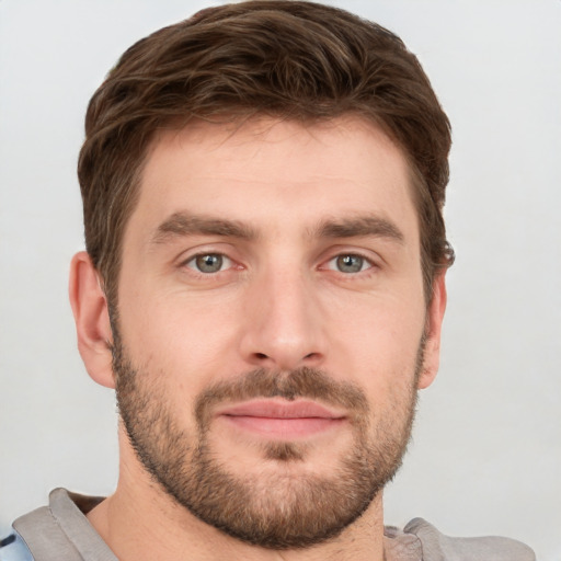 Joyful white young-adult male with short  brown hair and grey eyes