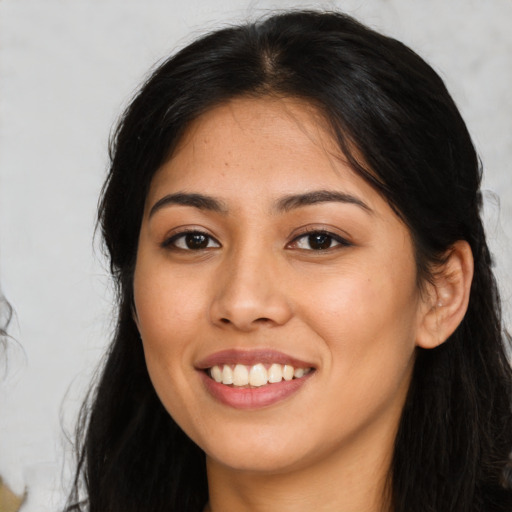 Joyful latino young-adult female with long  brown hair and brown eyes