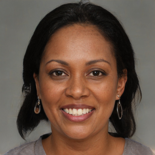 Joyful black adult female with medium  brown hair and brown eyes