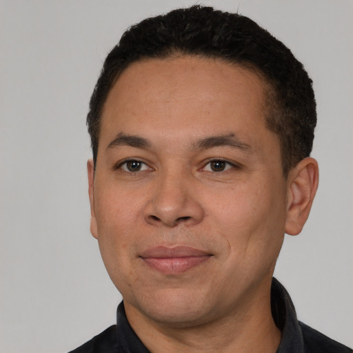 Joyful latino adult male with short  black hair and brown eyes