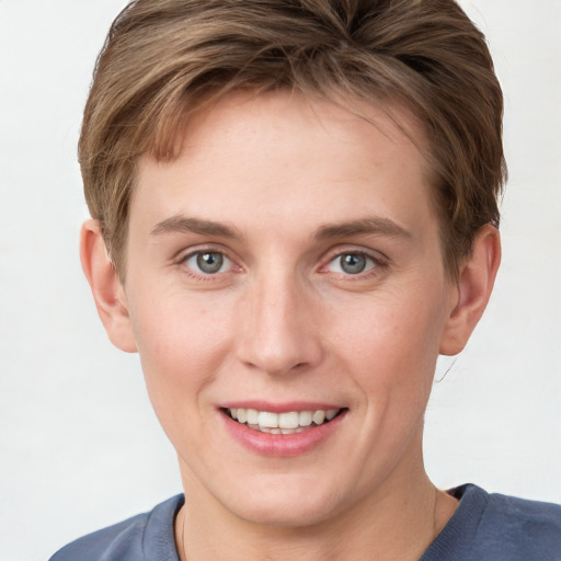 Joyful white young-adult female with short  brown hair and grey eyes