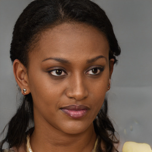 Joyful black young-adult female with long  brown hair and brown eyes