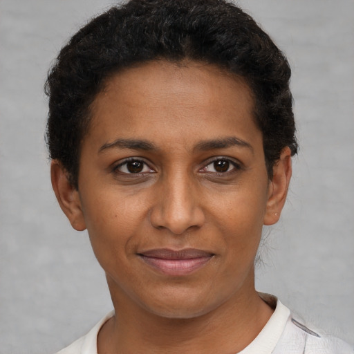 Joyful black young-adult female with short  brown hair and brown eyes
