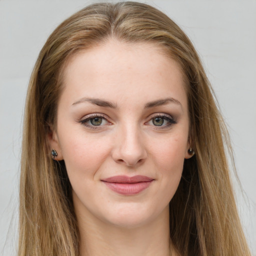 Joyful white young-adult female with long  brown hair and green eyes