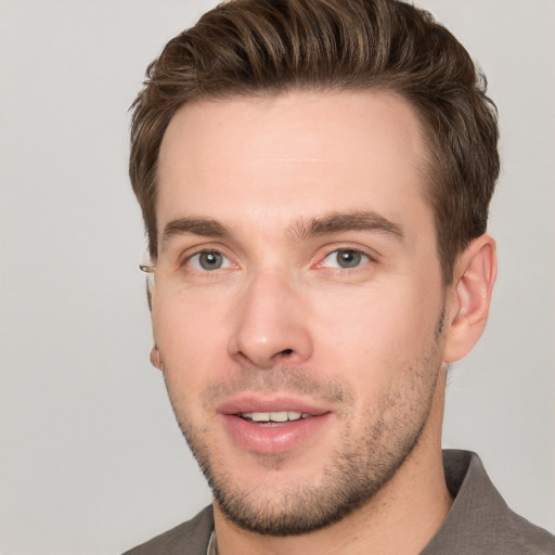 Joyful white young-adult male with short  brown hair and grey eyes