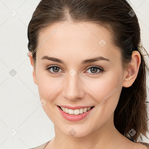 Joyful white young-adult female with medium  brown hair and grey eyes