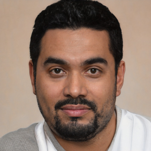 Joyful latino young-adult male with short  black hair and brown eyes