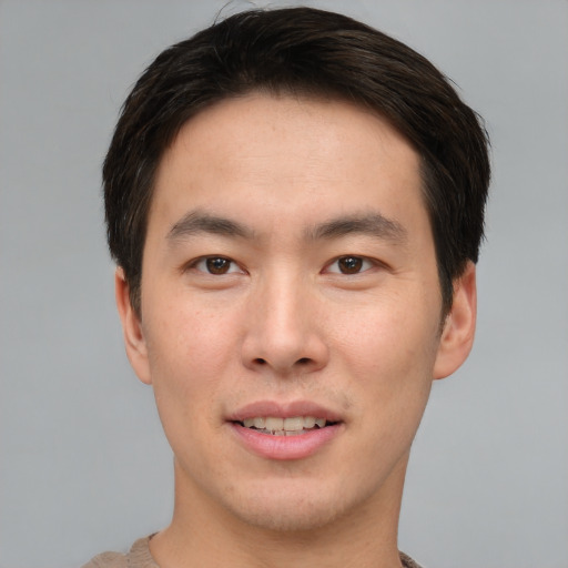 Joyful asian young-adult male with short  brown hair and brown eyes