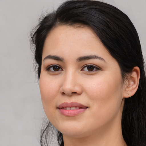 Joyful latino young-adult female with long  brown hair and brown eyes