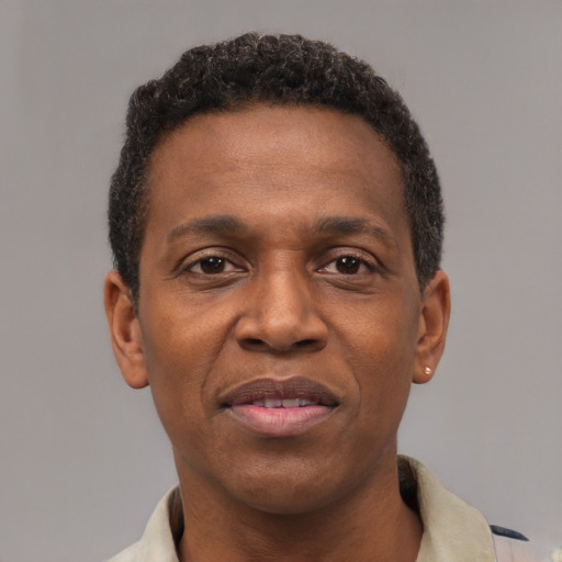 Joyful black adult male with short  brown hair and brown eyes