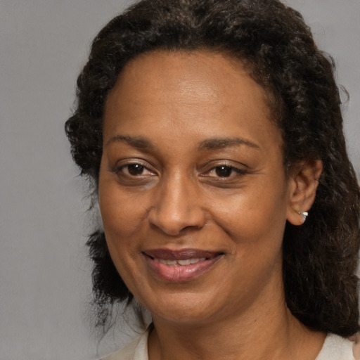 Joyful black adult female with medium  brown hair and brown eyes