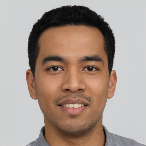 Joyful latino young-adult male with short  black hair and brown eyes