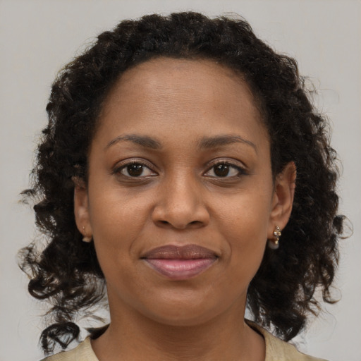 Joyful black young-adult female with long  brown hair and brown eyes