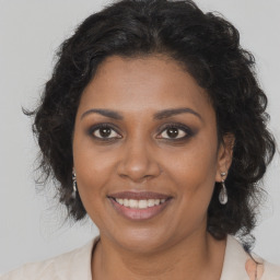 Joyful black adult female with long  brown hair and brown eyes