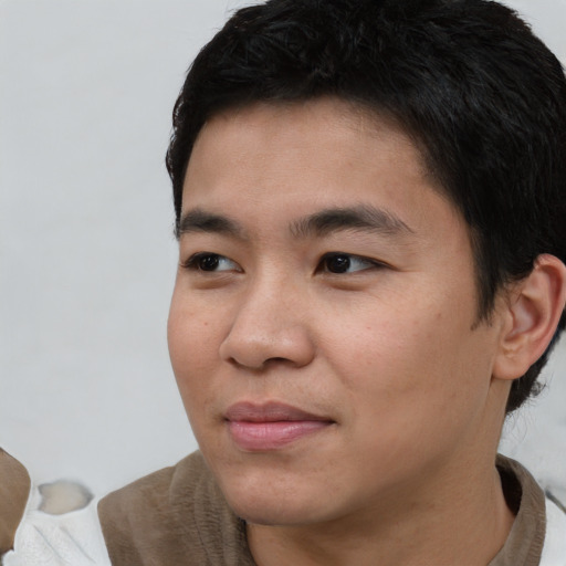 Joyful asian young-adult male with short  black hair and brown eyes