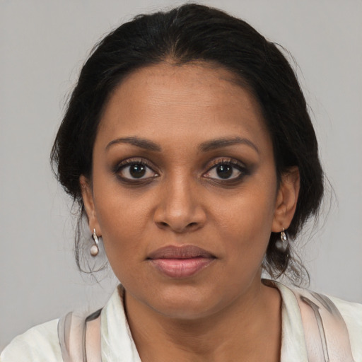 Joyful black young-adult female with medium  brown hair and brown eyes