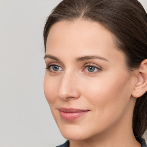 Joyful white young-adult female with medium  brown hair and grey eyes