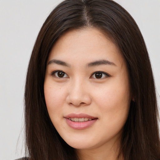 Joyful asian young-adult female with long  brown hair and brown eyes