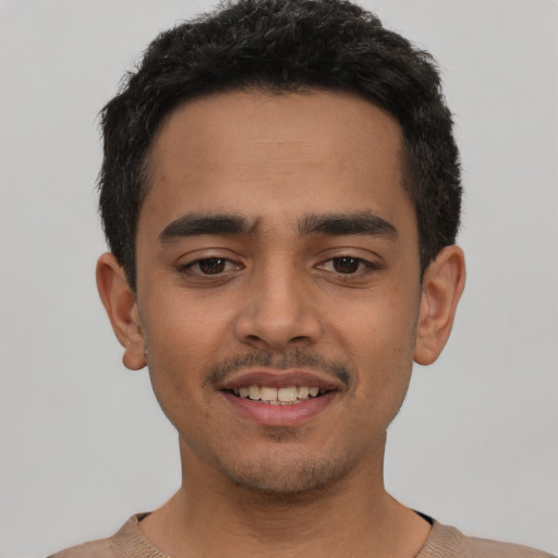 Joyful latino young-adult male with short  black hair and brown eyes