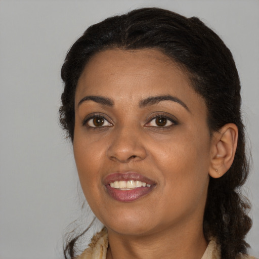 Joyful black adult female with long  black hair and brown eyes