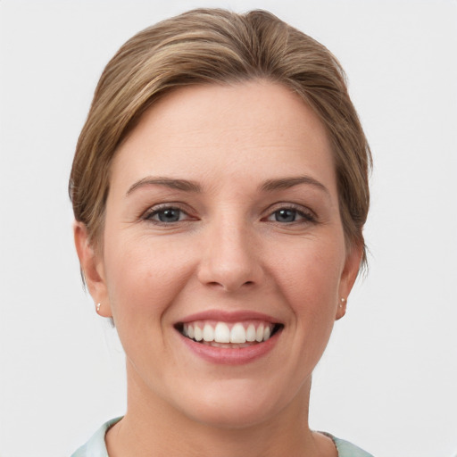 Joyful white young-adult female with short  brown hair and grey eyes