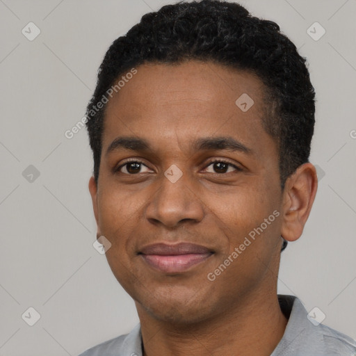 Joyful black young-adult male with short  black hair and brown eyes