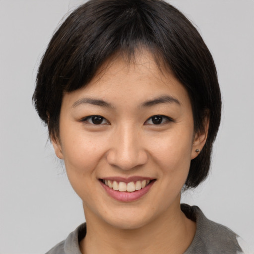 Joyful asian young-adult female with medium  brown hair and brown eyes