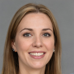 Joyful white young-adult female with long  brown hair and grey eyes