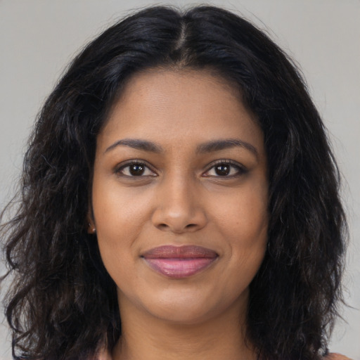 Joyful black young-adult female with long  brown hair and brown eyes