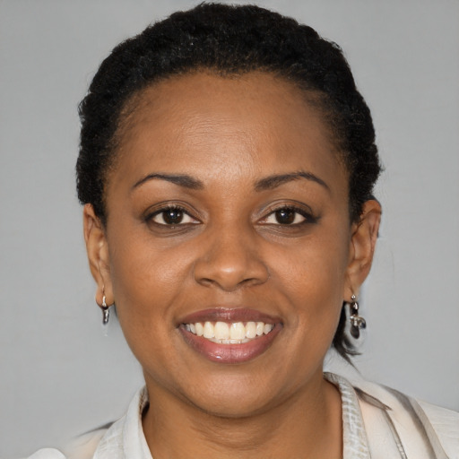 Joyful black young-adult female with short  black hair and brown eyes