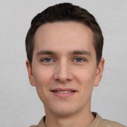 Joyful white young-adult male with short  brown hair and grey eyes